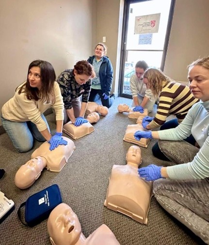 A group of people practicing cpr on mannequinsAI-generated content may be incorrect.