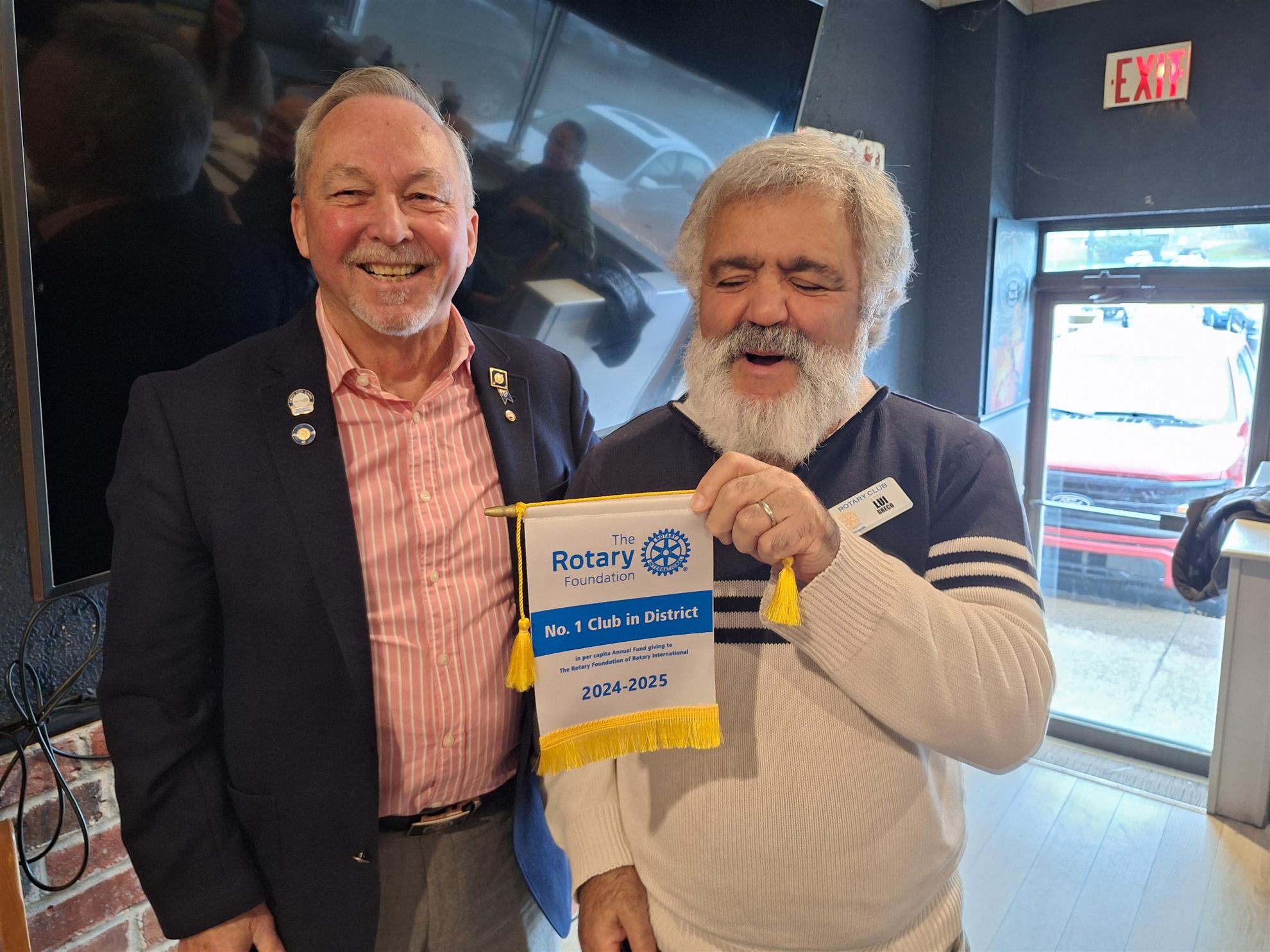 The image shows the District governor Marcel Gervais presenting the award for highest giving per capita to Rotary Dartmouth of Dartmouth, it was received by Lui Greco of the club