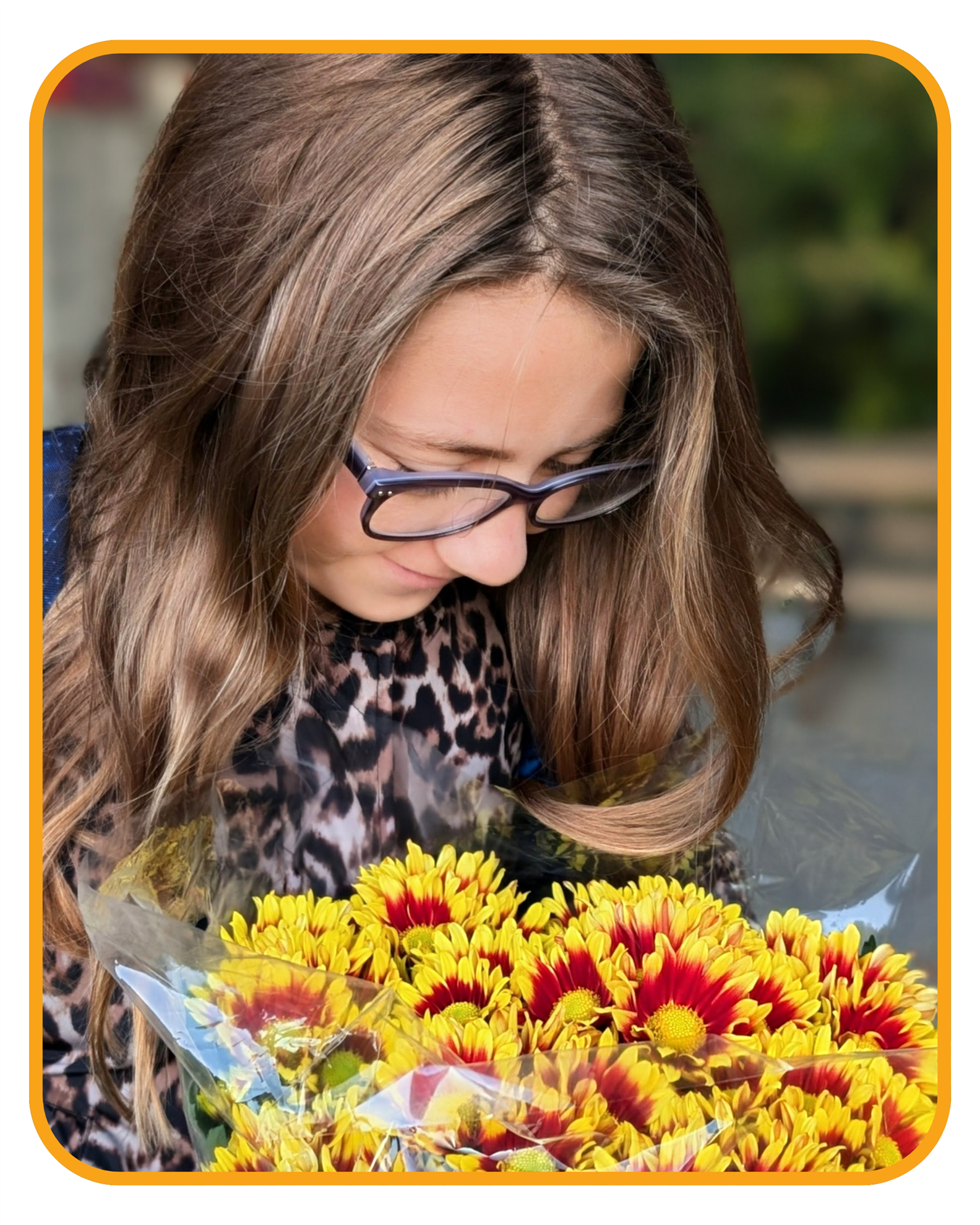 A child receiving a Thanksgiving mum.
