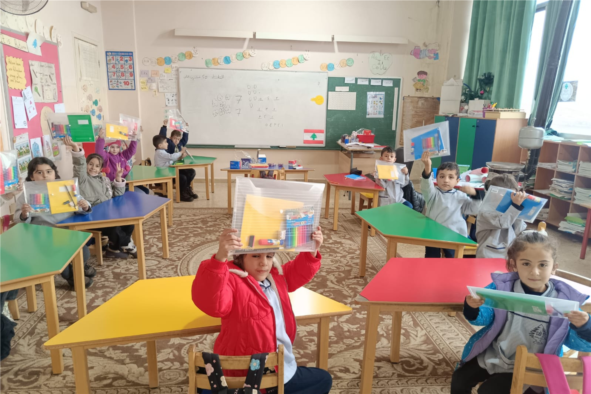Students at the Baalbek Kindergarten School Complex holding school supply kits