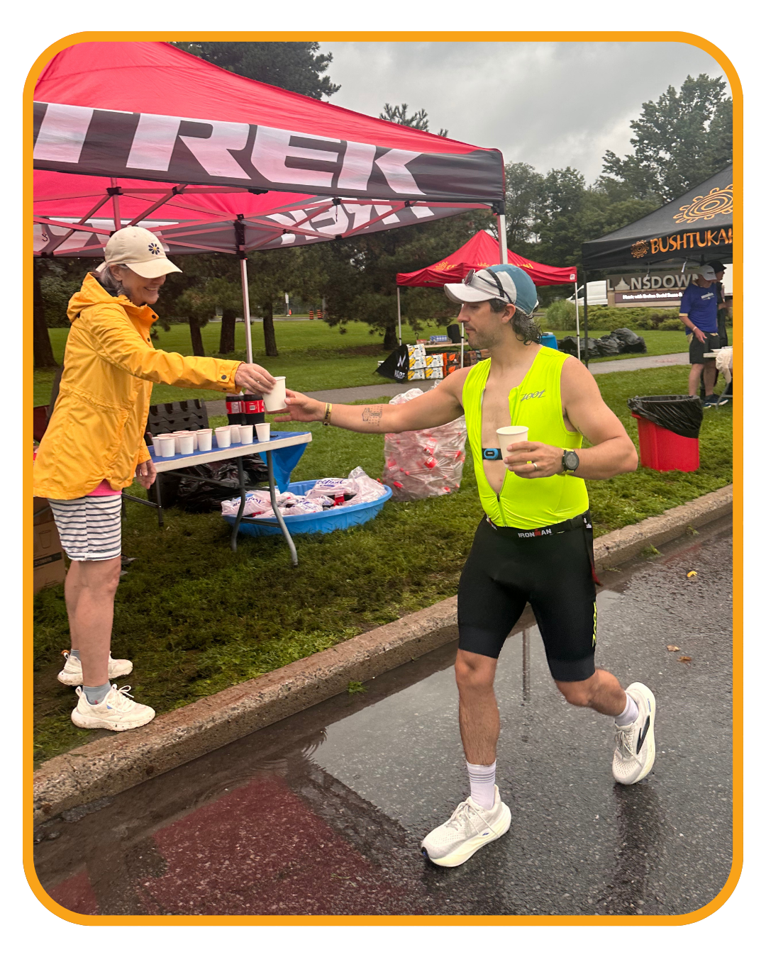 RCWO volunteers serving athletes with a smile in rainy conditions