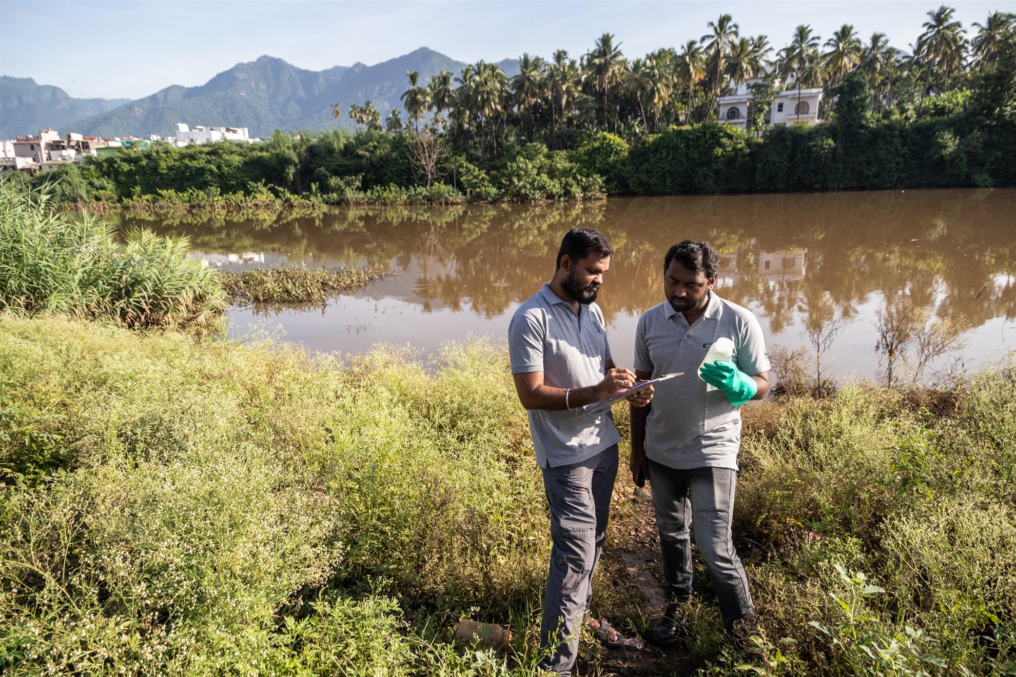 Arun Venkatesh og Vincent Matthew fra Verdens naturfond i India tester vannet i Bhavani-elven under en ESRAG-oppryddingsøvelse i Sirumugai i India, juni 2024.