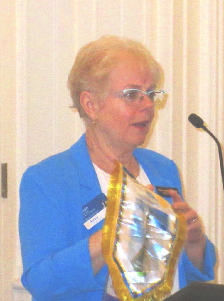 Manon Mitchell presenting several club banners