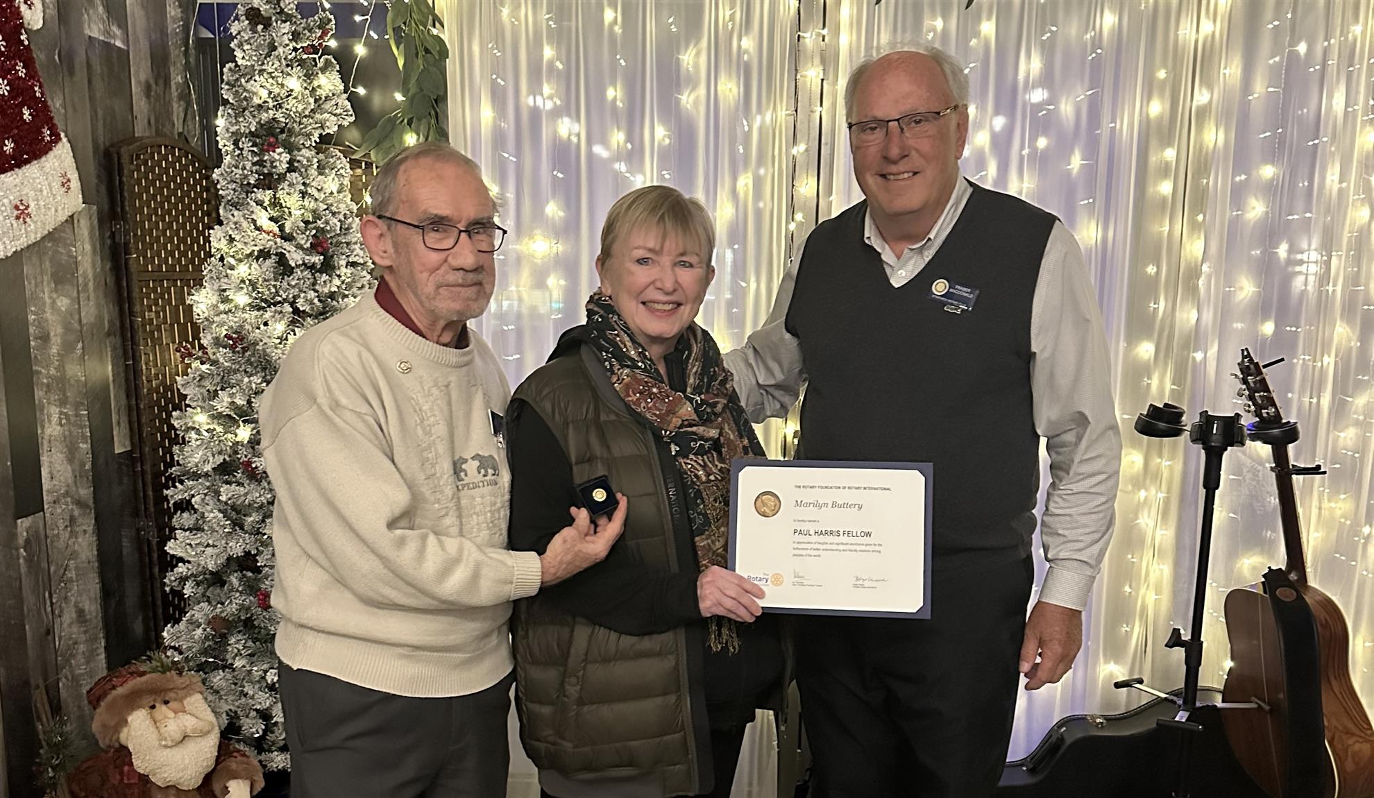 Two Rotarians present Marilyn Buttery with a Paul Harris Fellow for her dedication and commitment the Strathroy Rotary Club.