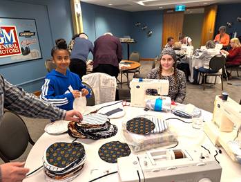 A group of people sewingDescription automatically generated