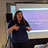 A person standing in front of a projector screenDescription automatically generated