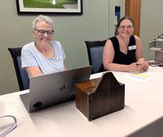 Women sitting at a table with laptopsDescription automatically generated