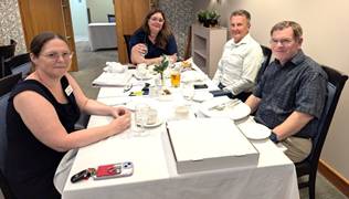 A group of people sitting at a tableDescription automatically generated