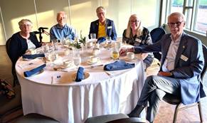 A group of people sitting around a round tableDescription automatically generated