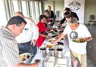 A group of people serving foodDescription automatically generated