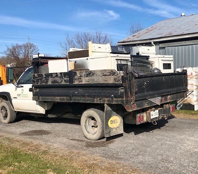 white pick up truck with stoves, dryers, and washing machines
