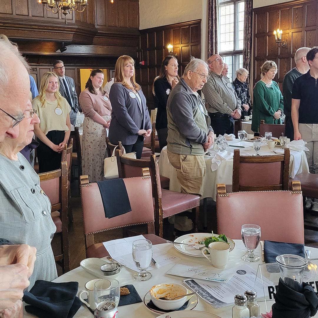 A group of people standing in a roomAI-generated content may be incorrect.