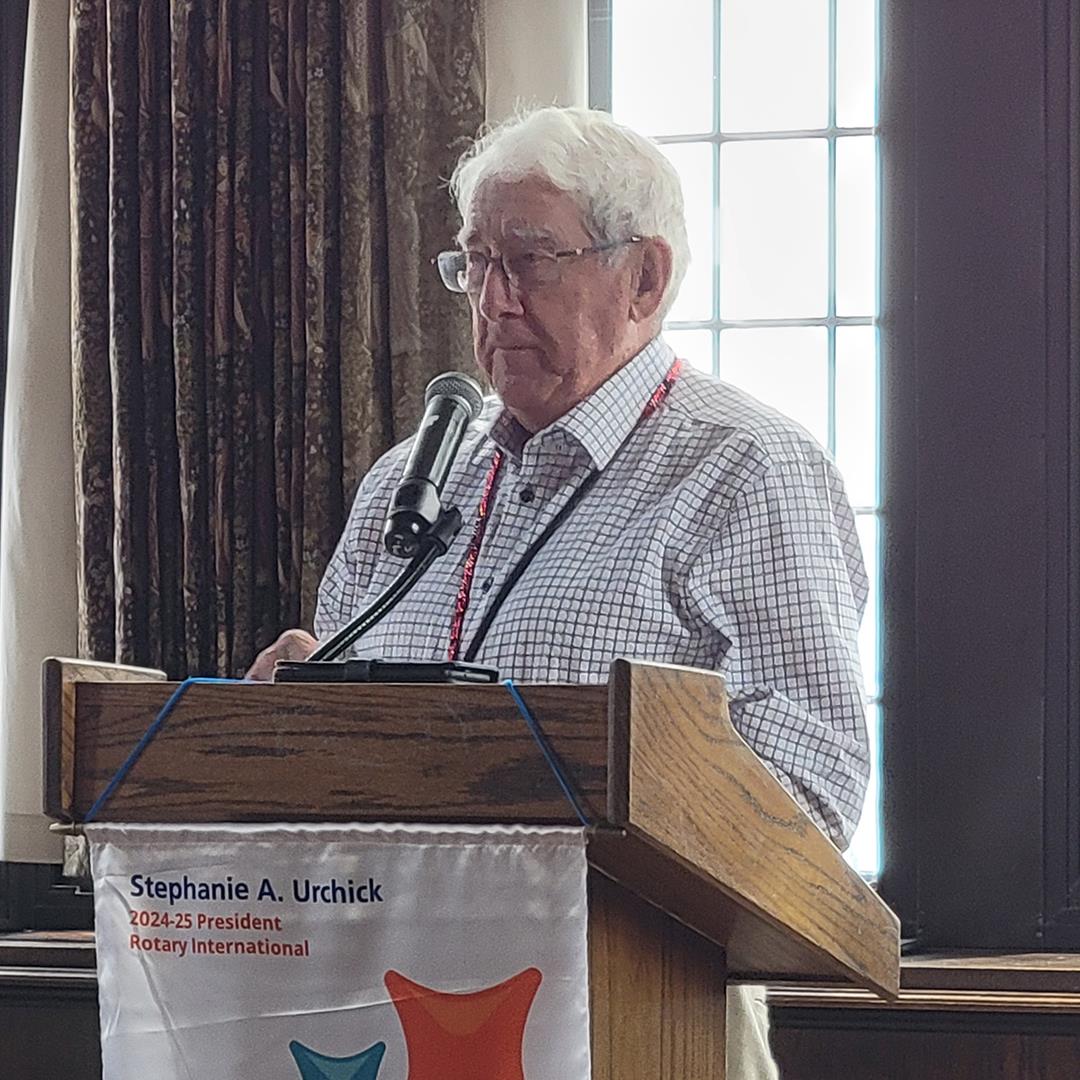 An old person standing at a podiumAI-generated content may be incorrect.