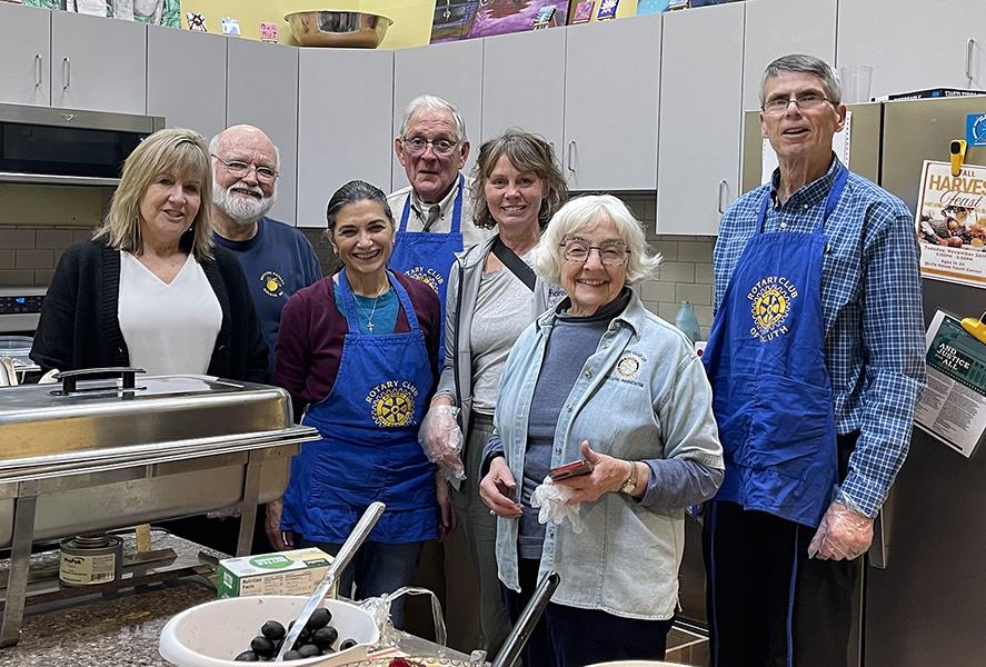 A group of people standing in a kitchenDescription automatically generated