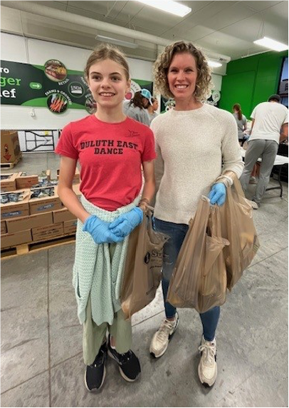 A person and a child holding plastic bagsAI-generated content may be incorrect.