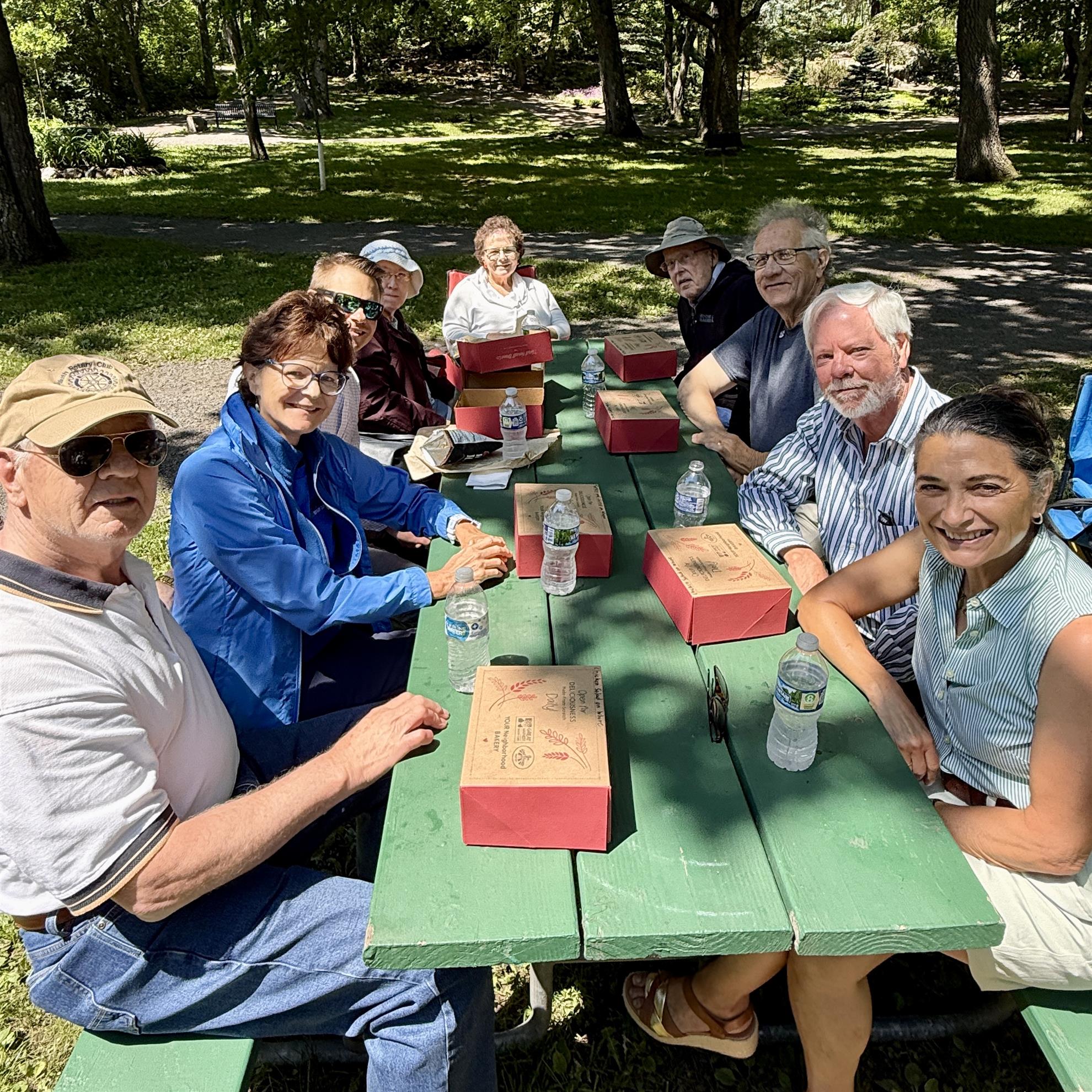 A group of people sitting at a picnic tableAI-generated content may be incorrect.