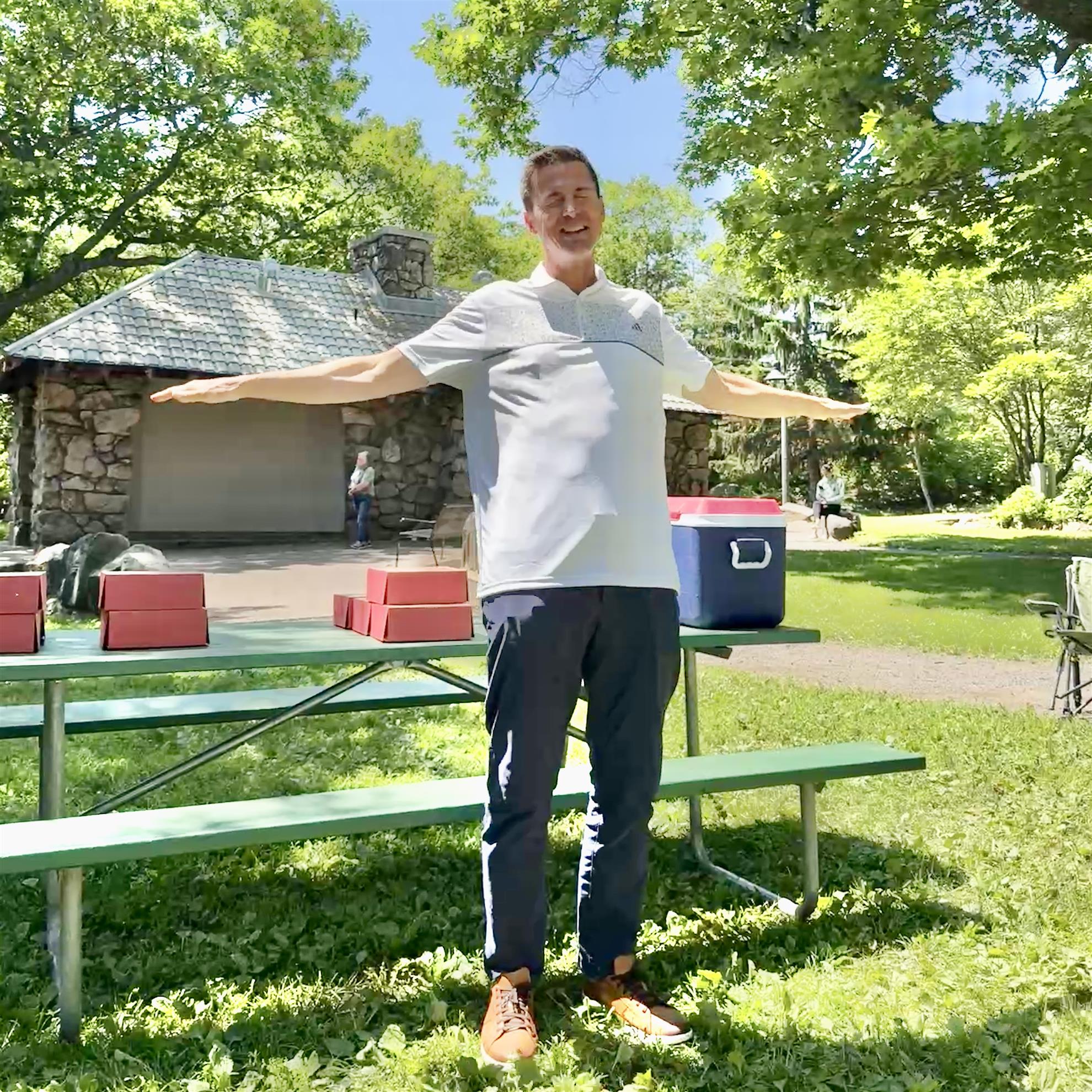 A person standing in a park with his arms outAI-generated content may be incorrect.