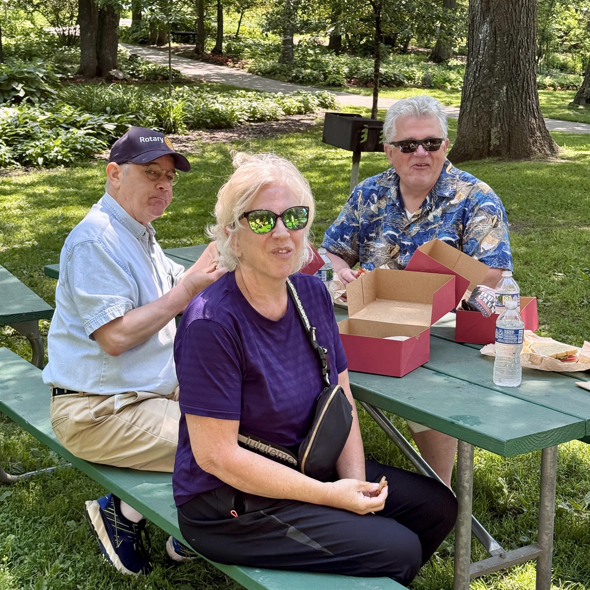 A group of people sitting at a picnic tableAI-generated content may be incorrect.