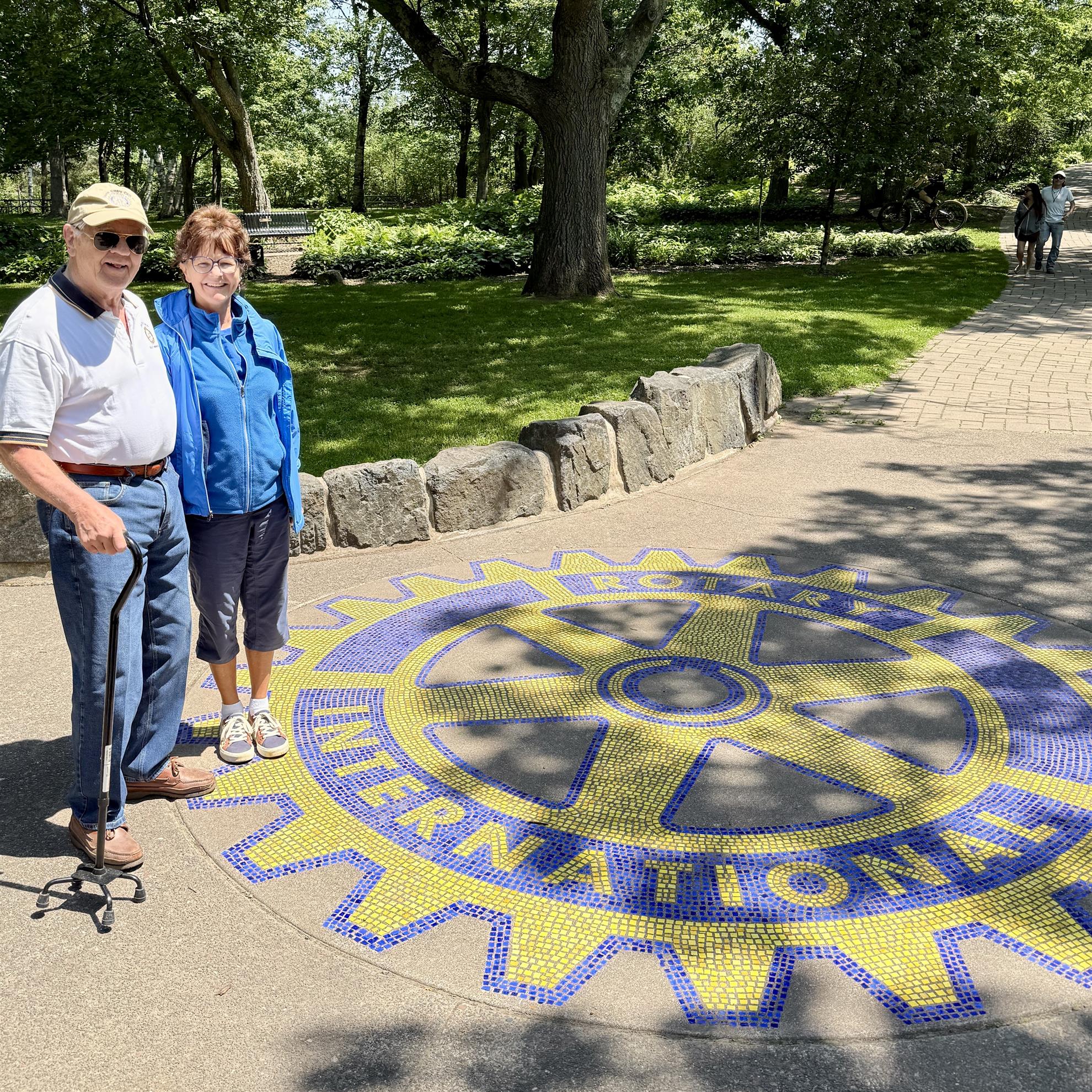 A person and person standing in front of a logoAI-generated content may be incorrect.