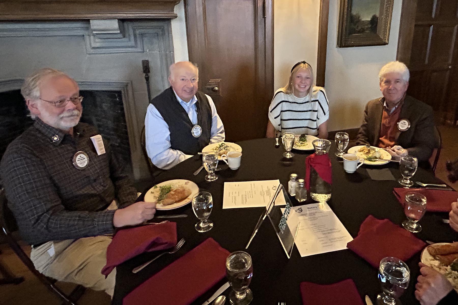A group of people sitting around a tableDescription automatically generated