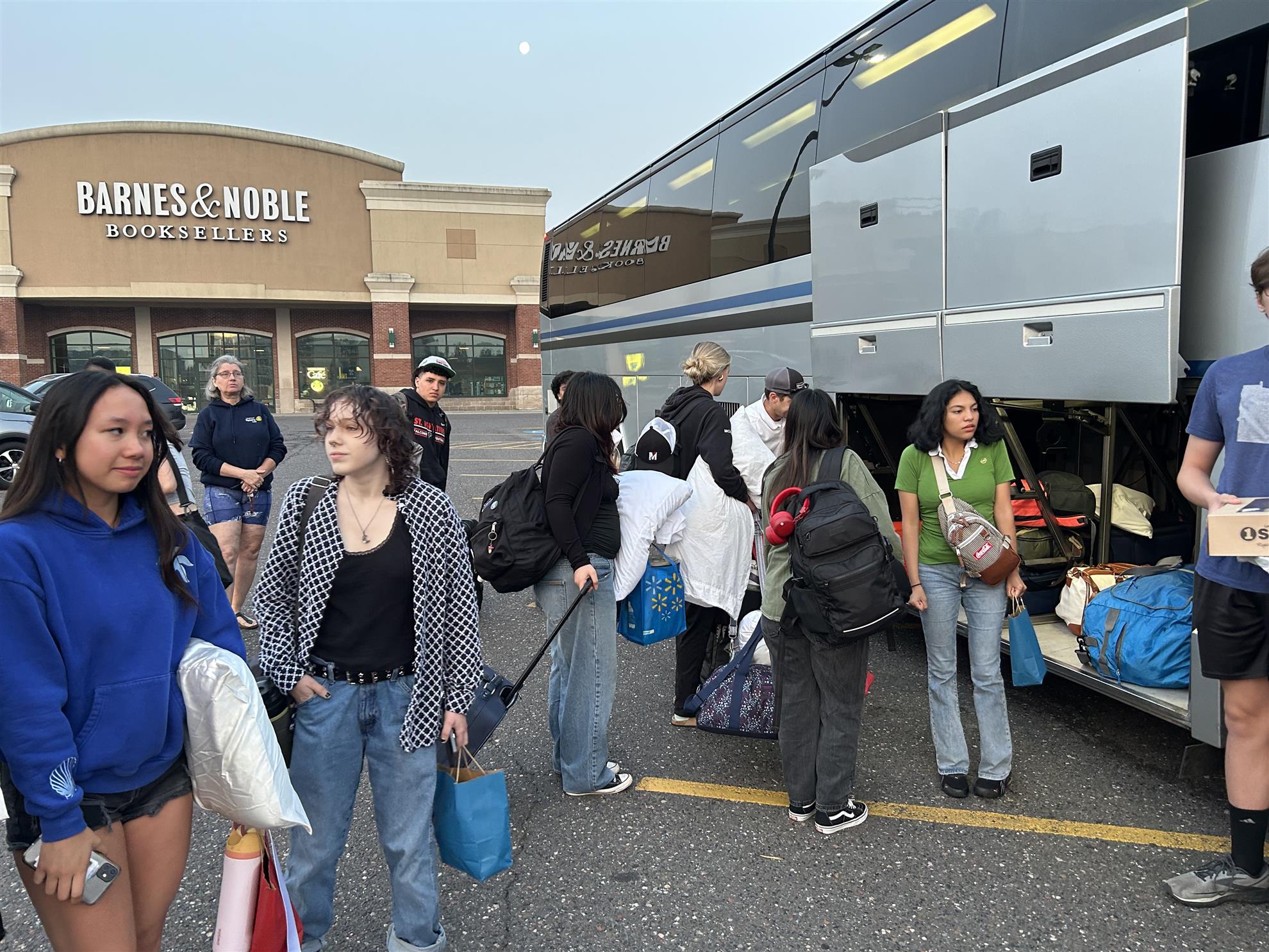 A group of people standing next to a busAI-generated content may be incorrect.