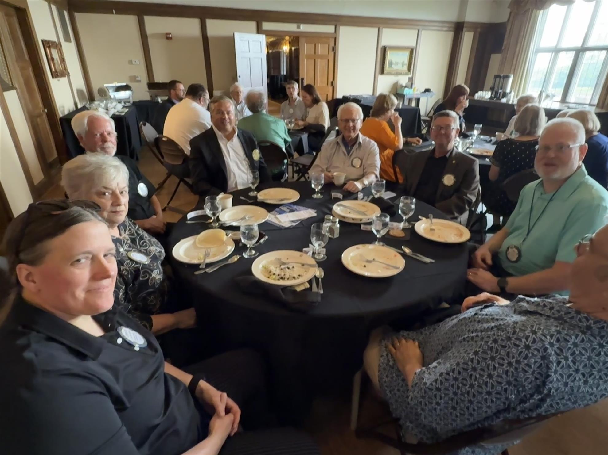 A group of people sitting around a tableAI-generated content may be incorrect.