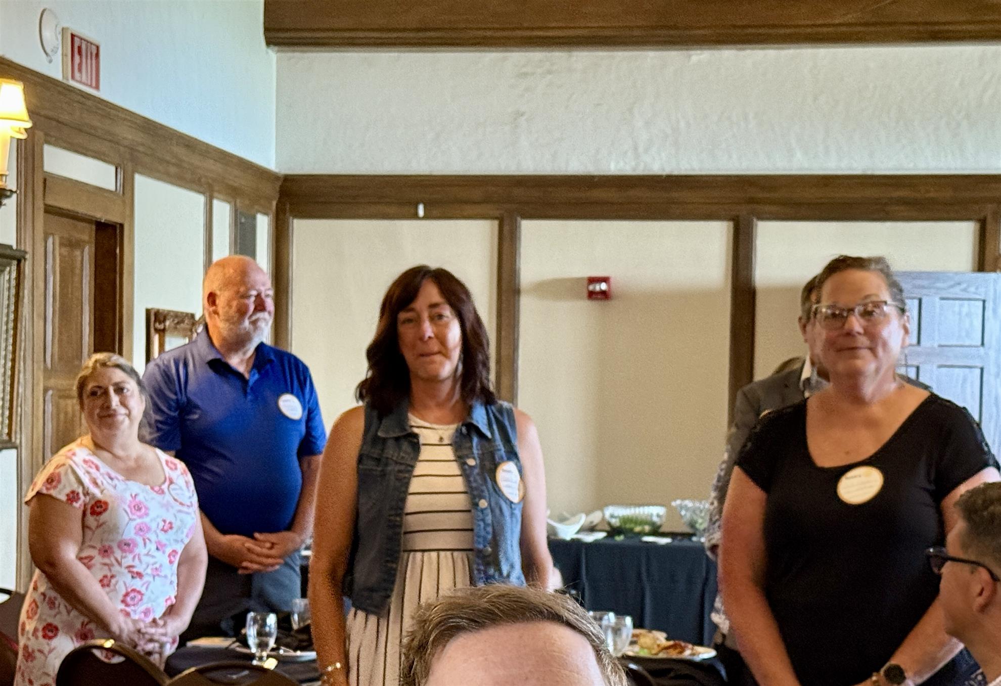 A group of people standing in a roomAI-generated content may be incorrect.