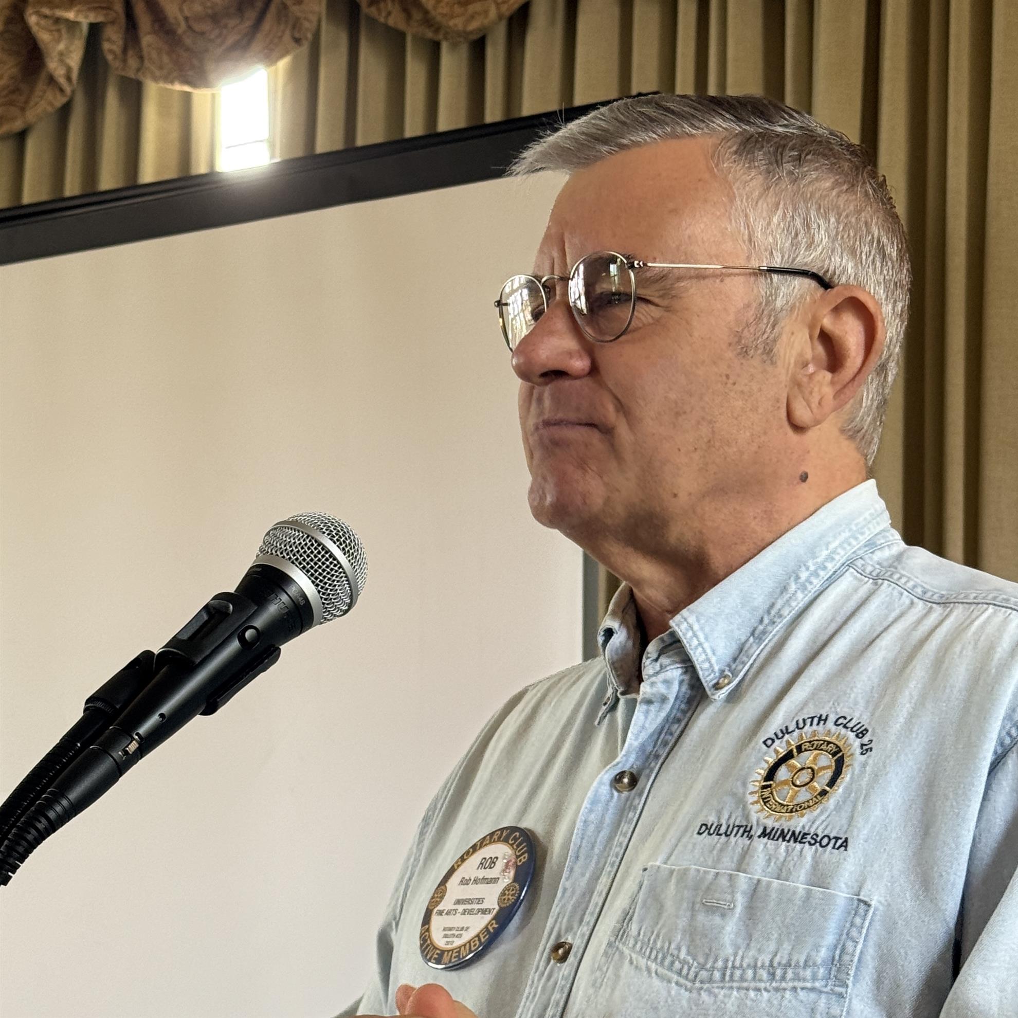 A person standing in front of a microphoneAI-generated content may be incorrect.