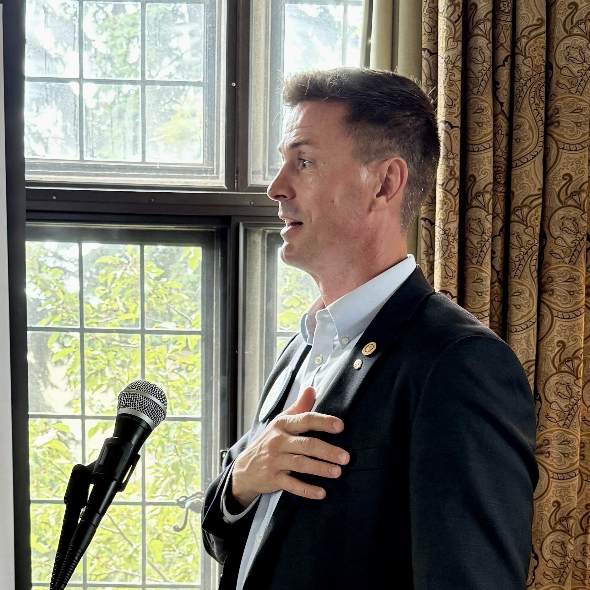 A person standing in front of a microphoneAI-generated content may be incorrect.