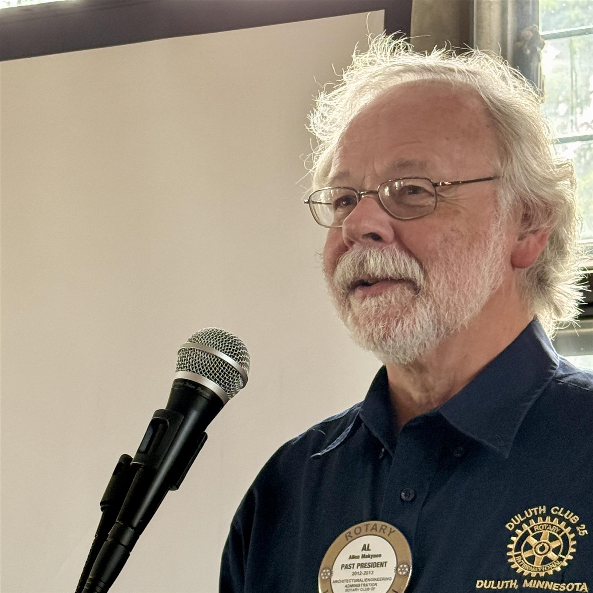 A person standing in front of a microphoneAI-generated content may be incorrect.