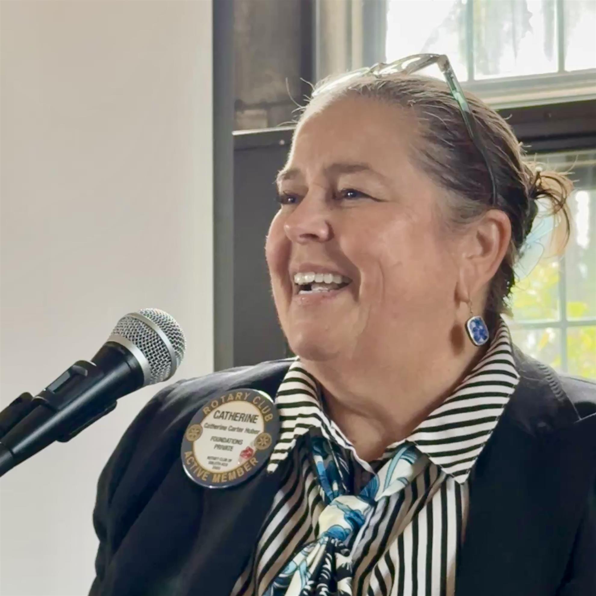 A person smiling at a microphoneAI-generated content may be incorrect.