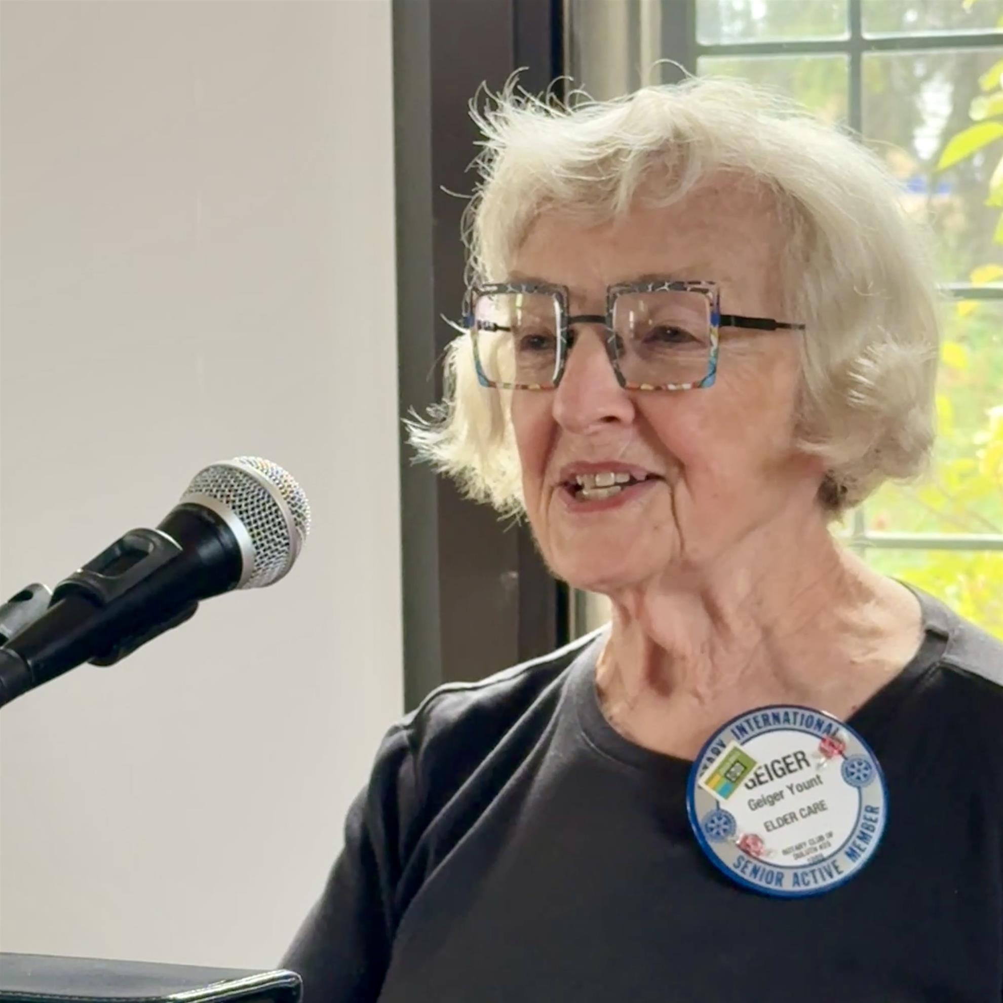 A person standing in front of a microphoneAI-generated content may be incorrect.