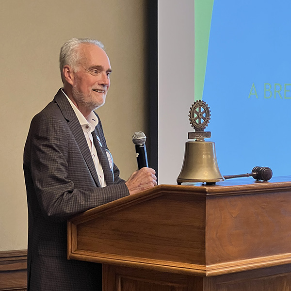A person standing at a podium with a microphoneDescription automatically generated