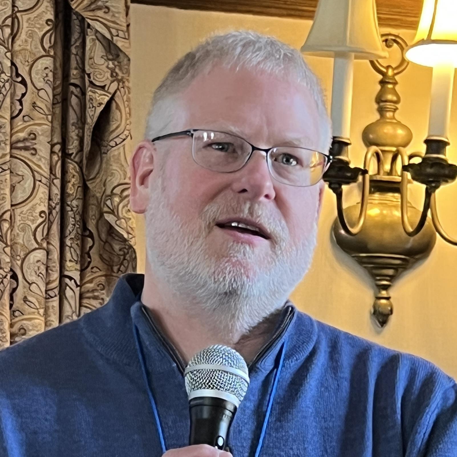 A person with a microphoneAI-generated content may be incorrect.