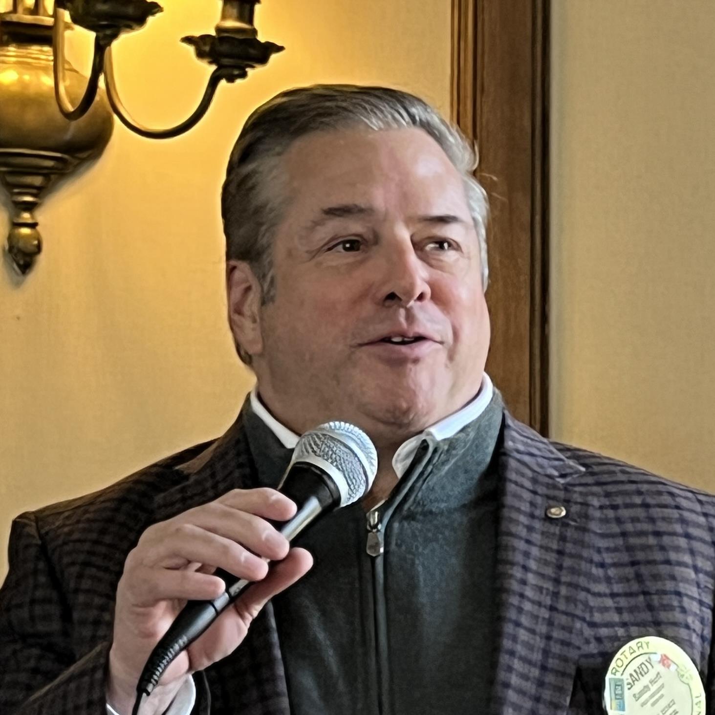 A person speaking into a microphoneAI-generated content may be incorrect.