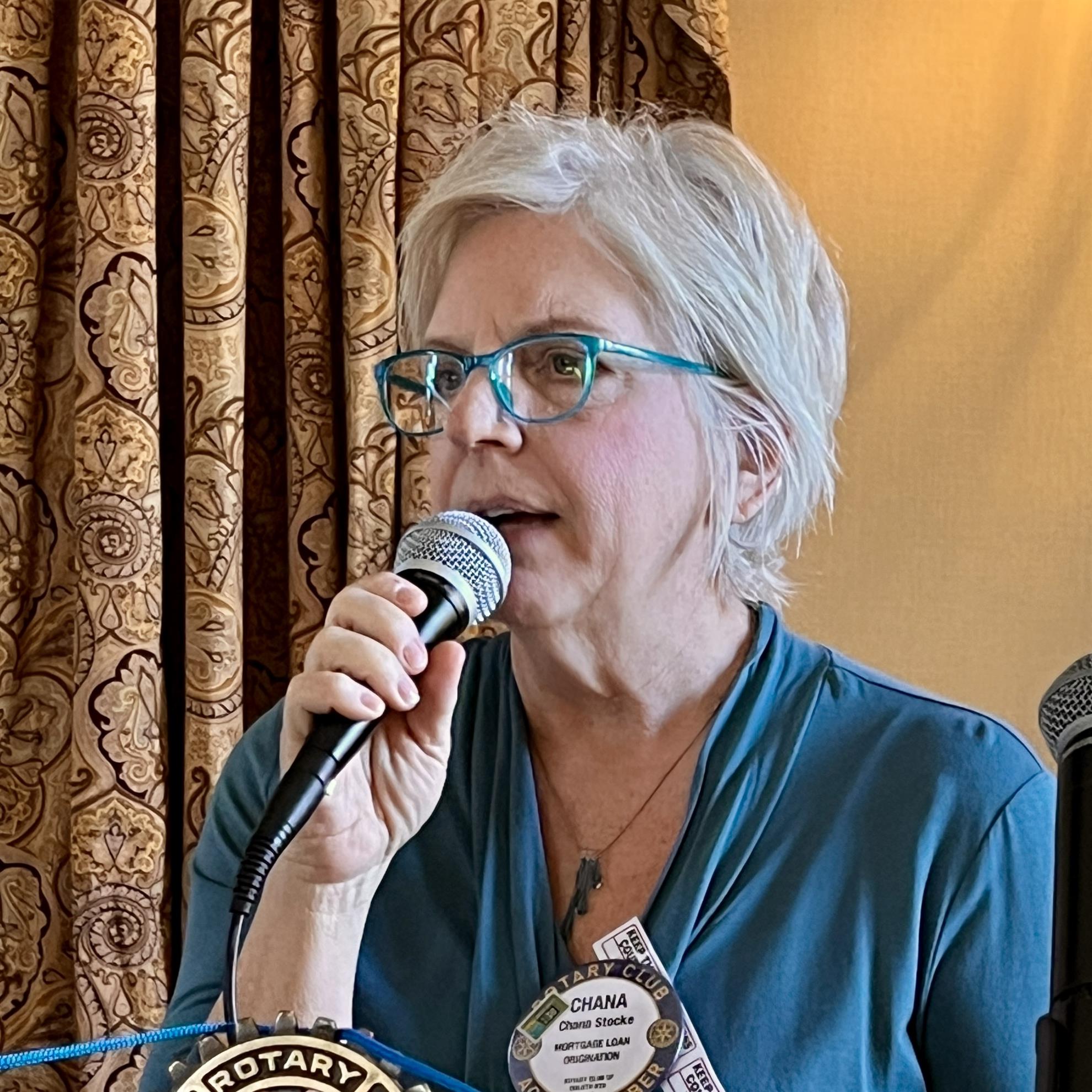 A person speaking into a microphoneAI-generated content may be incorrect.