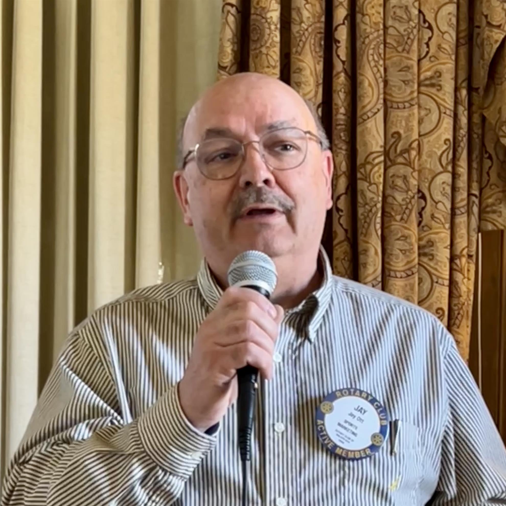 A person holding a microphoneAI-generated content may be incorrect.