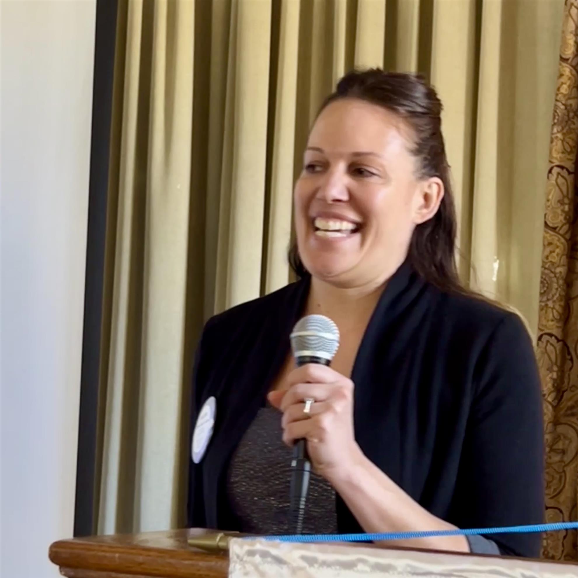 A person holding a microphoneAI-generated content may be incorrect.