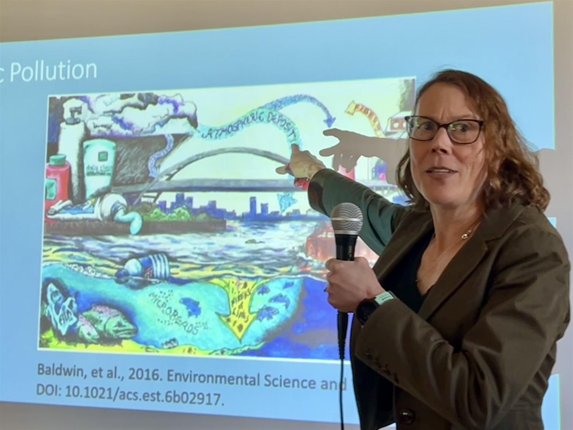 A person standing in front of a projector screenAI-generated content may be incorrect.