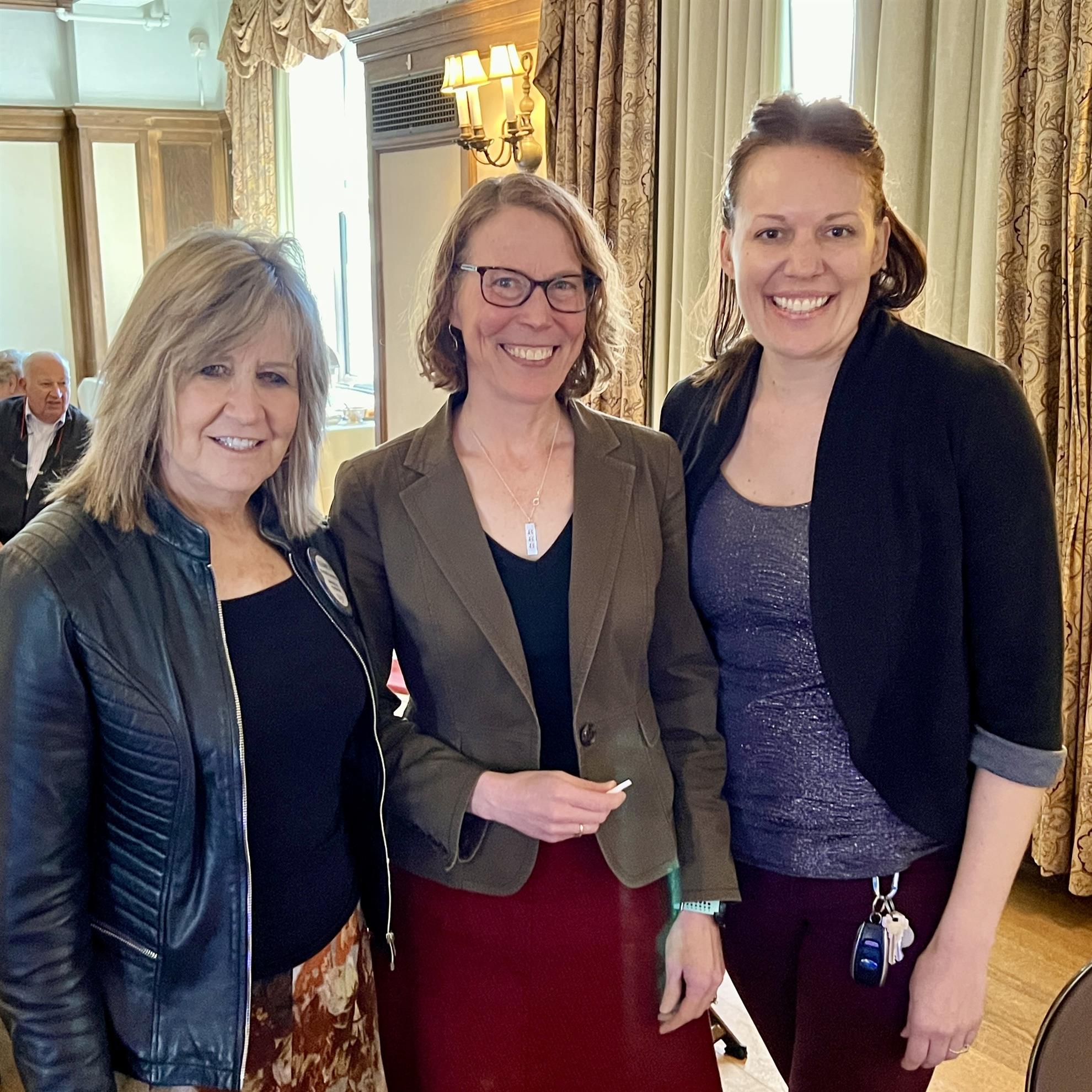 A group of women standing together smilingAI-generated content may be incorrect.