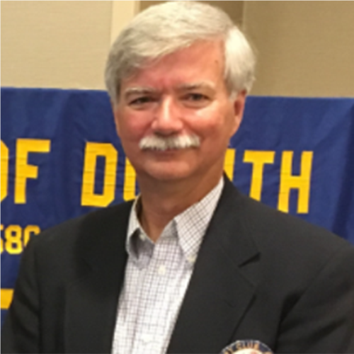 A person and person standing in front of a blue bannerAI-generated content may be incorrect.