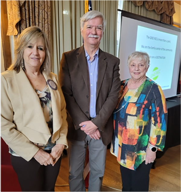 A group of people standing in front of a projector screenAI-generated content may be incorrect.