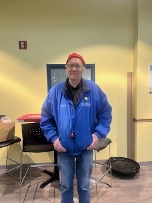 A person in a blue jacketDescription automatically generated
