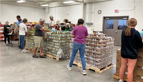 A group of people in a warehouseAI-generated content may be incorrect.