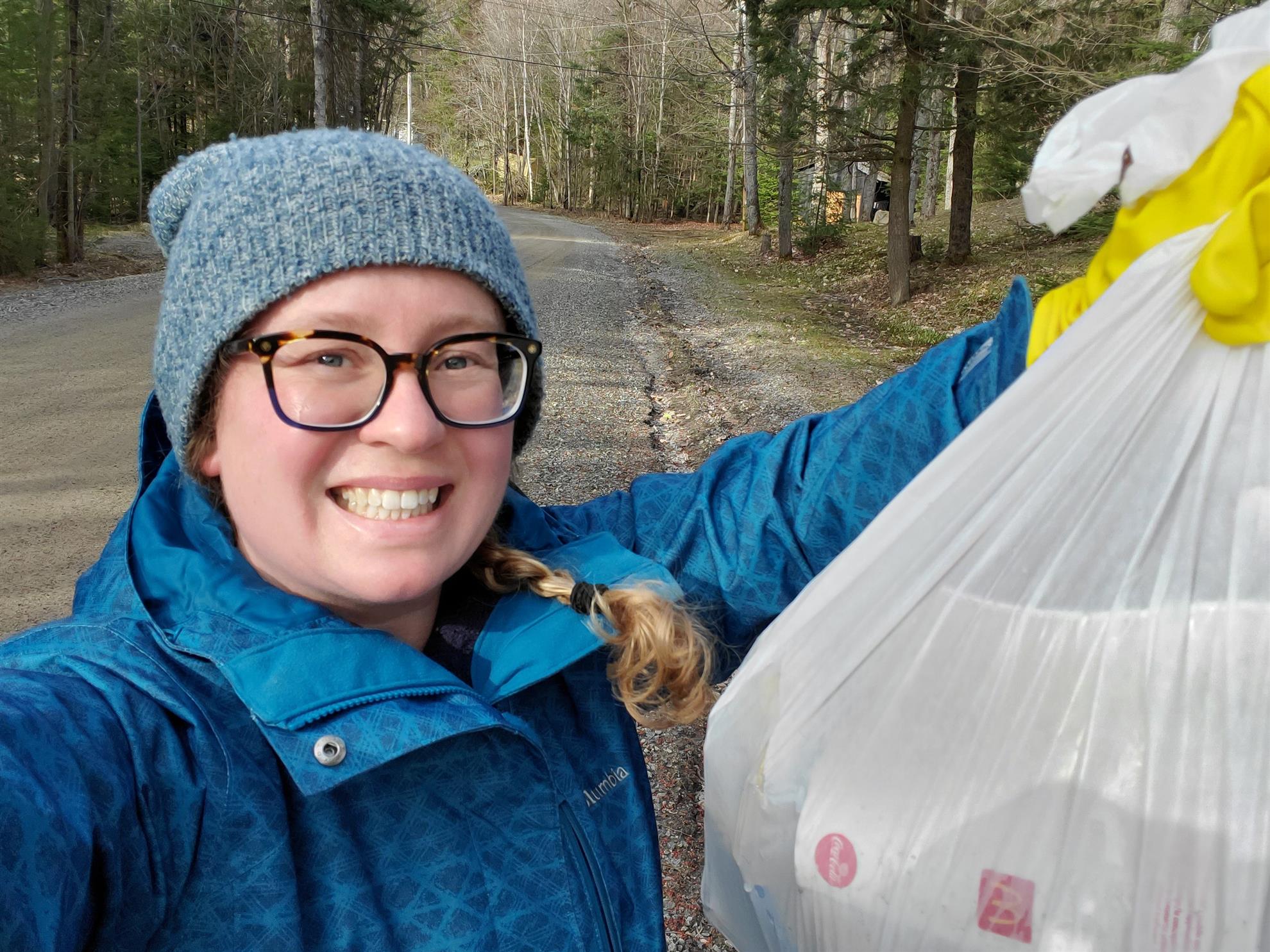 Amber holds up a bag of collected trash.