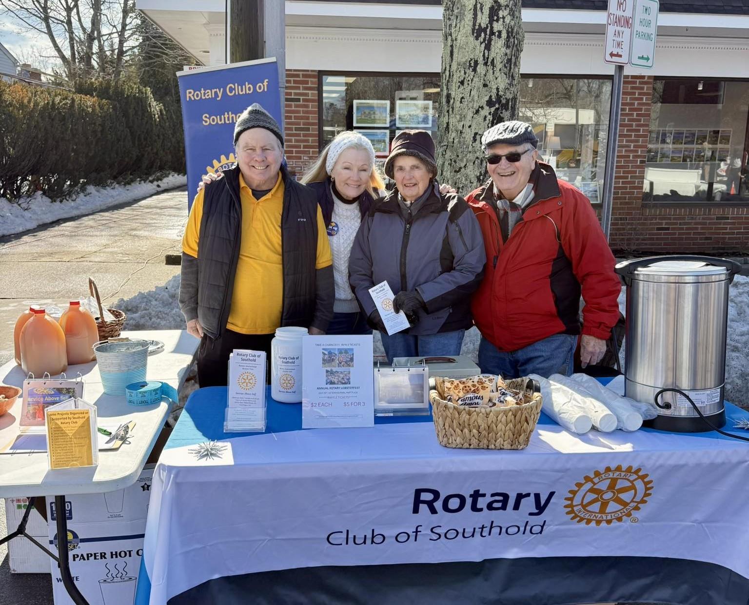 Four people standing behind a table