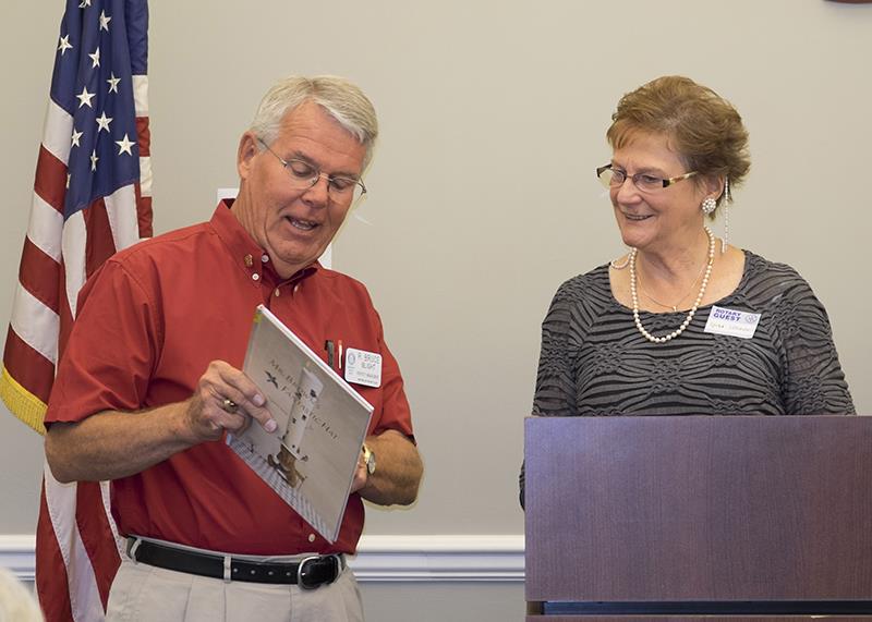 Speaker Chair Bruce Blight has etiquette expert Lynda Simmons sign the plate of a book donated to the Bedford Library in appreciation of Ms. Simmons' appearance
