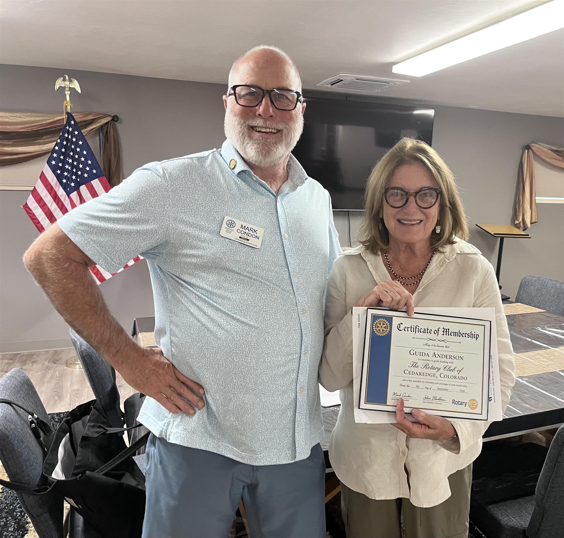 Rotary Club President Mark Condon welcomes new member Guida Anderson. 