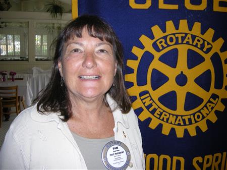 Woman in front of Rotary banner
