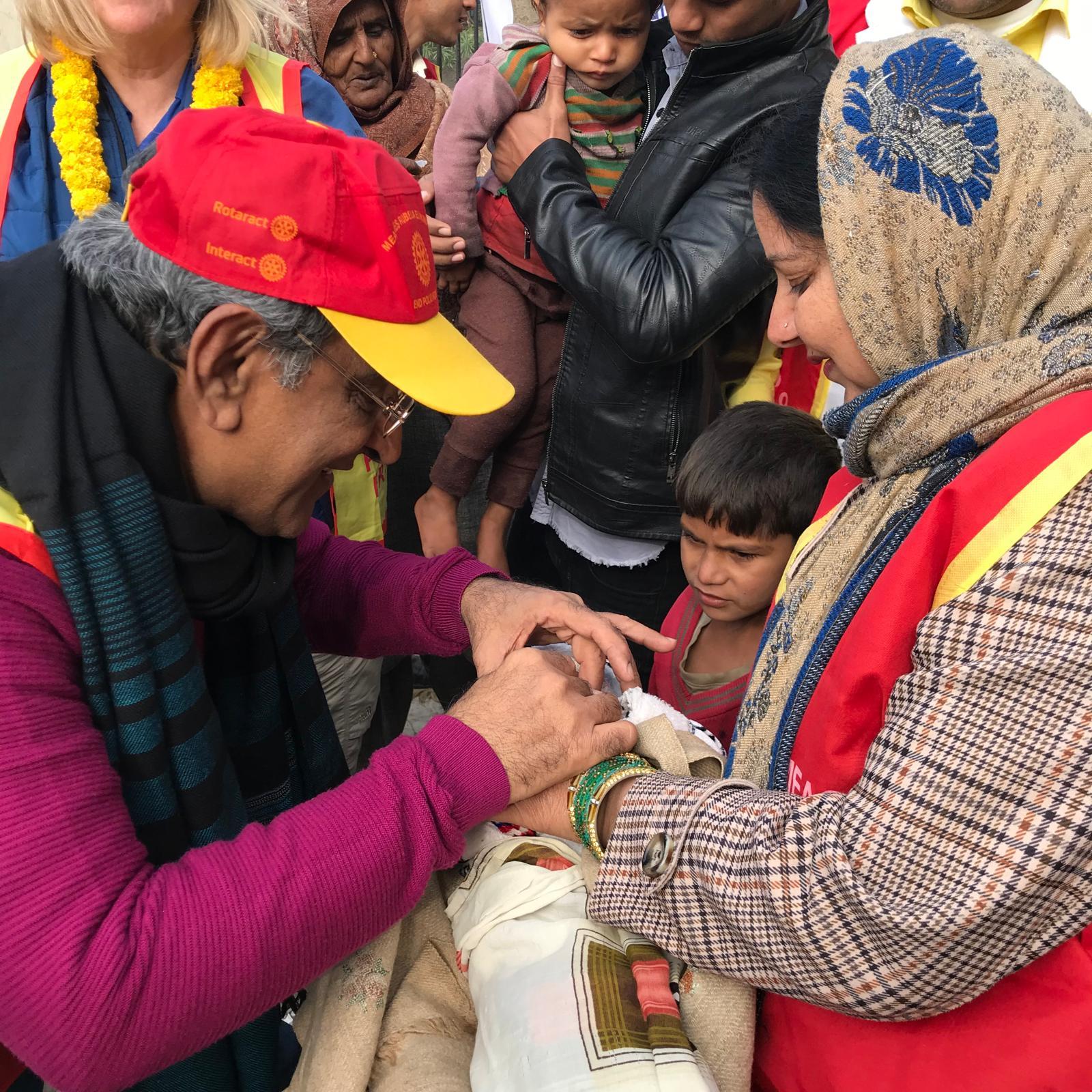 PP Hiro giving polio immunization drops to a newborn